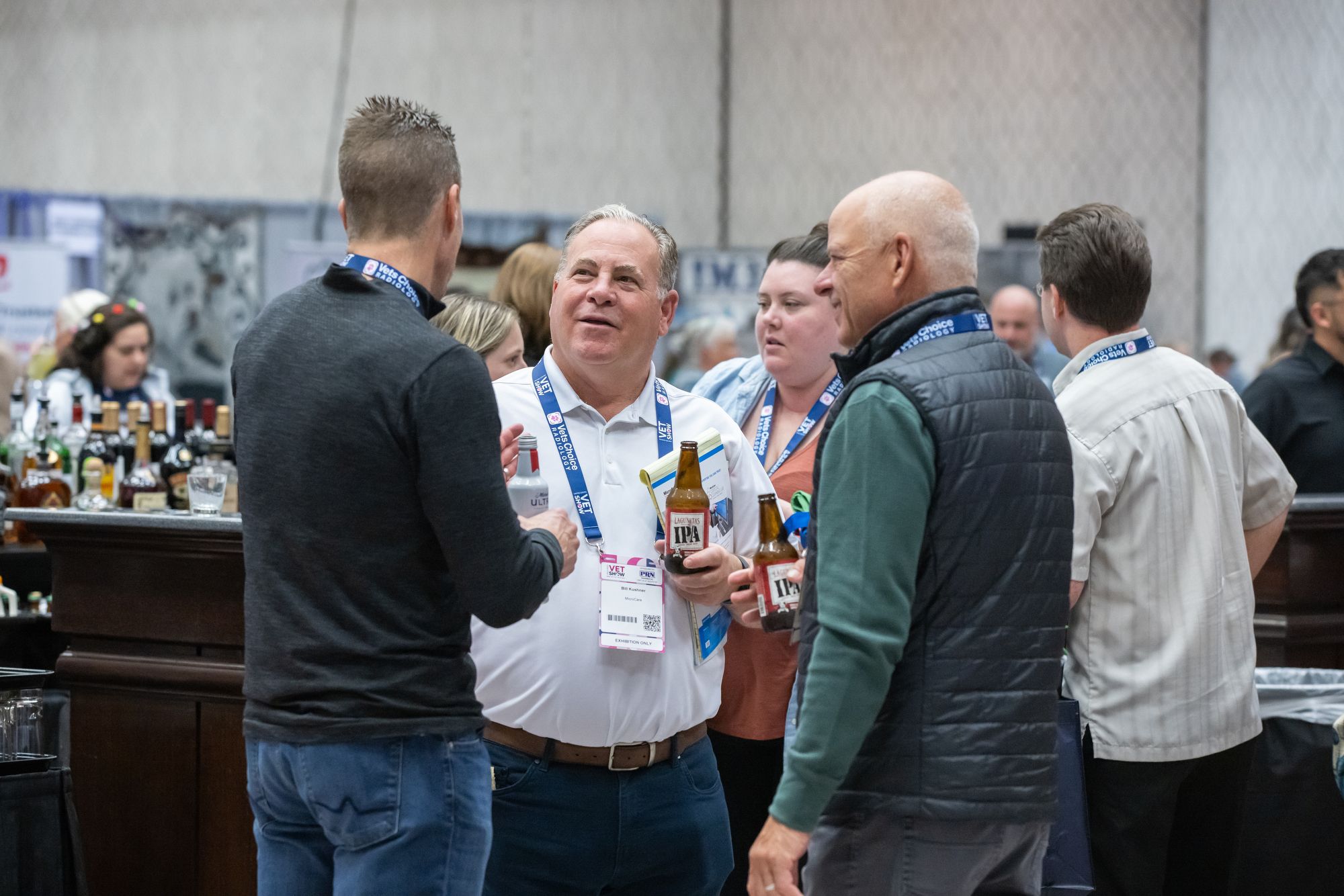 3 men holding drinks and socializing